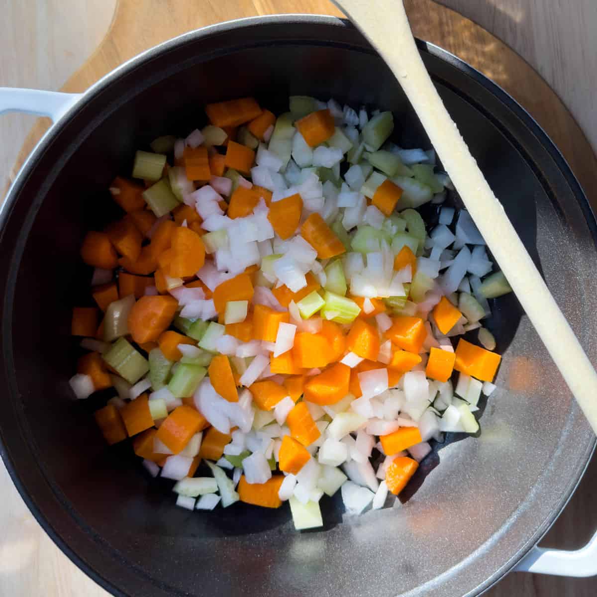Large soup pot with saut&eacute;ing onions, carrots, celery, and garlic.