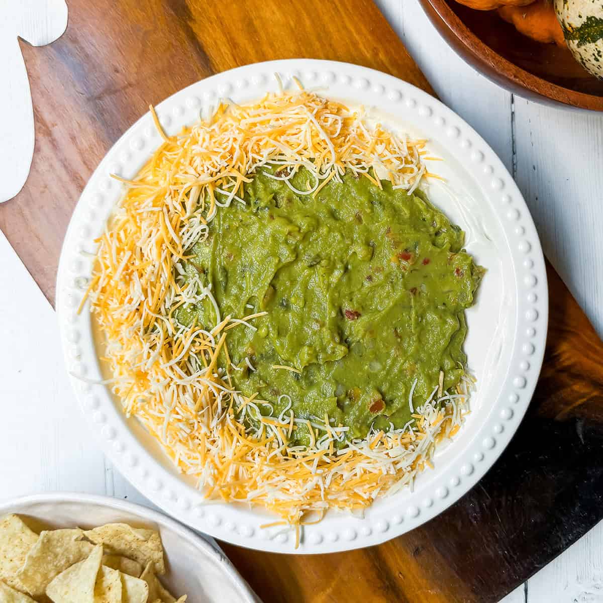 Adding a cheese layer around the edges of a Halloween 7 Layer Dip.