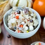 Fall snack mix with Chex cereal, autumn candies, pretzels and white chocolate in a bowl on a Harvest table.