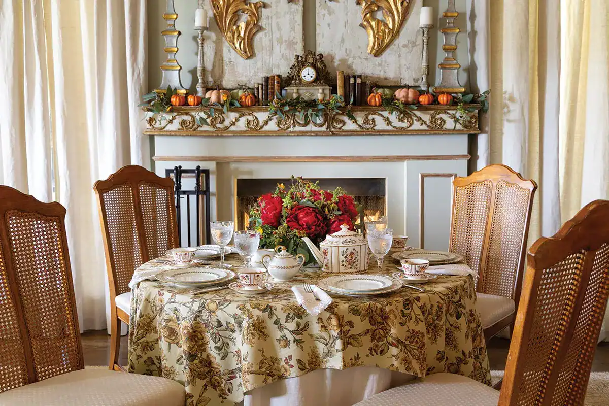 Fall harvest table setting in front of a fireplace decorated for fall.