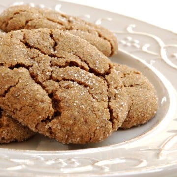Square image of stacked ginger spice cookies on a white plate ready for serving.