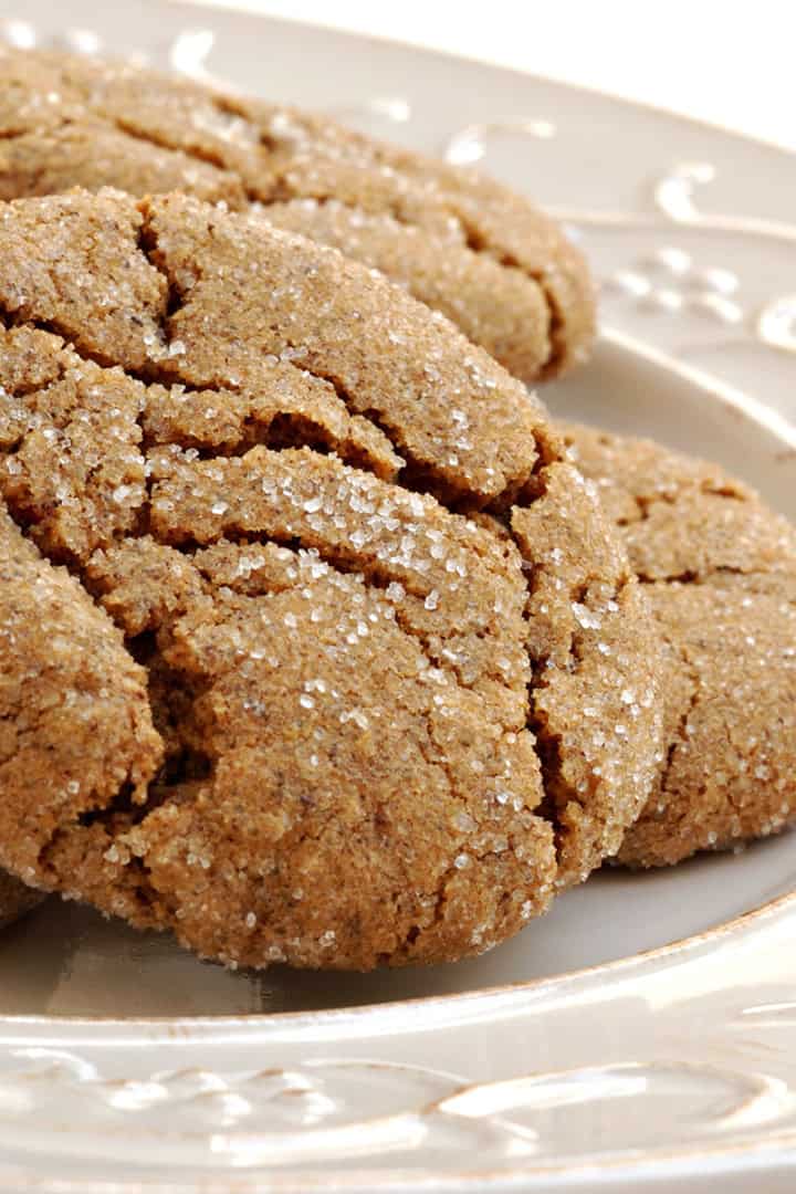Square image of stacked ginger spice cookies on a white plate ready for serving.