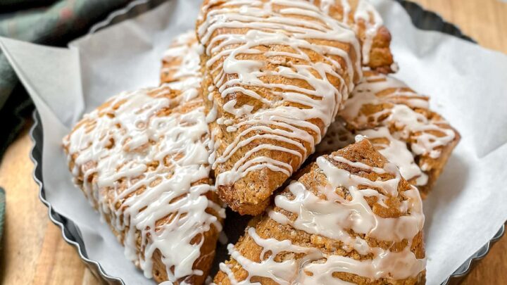 Side top closeup view of glazed Gingerbread Scones on a round wood board.