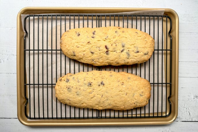 Top horizontal view of cooling baked biscotti logs on a wire rack.