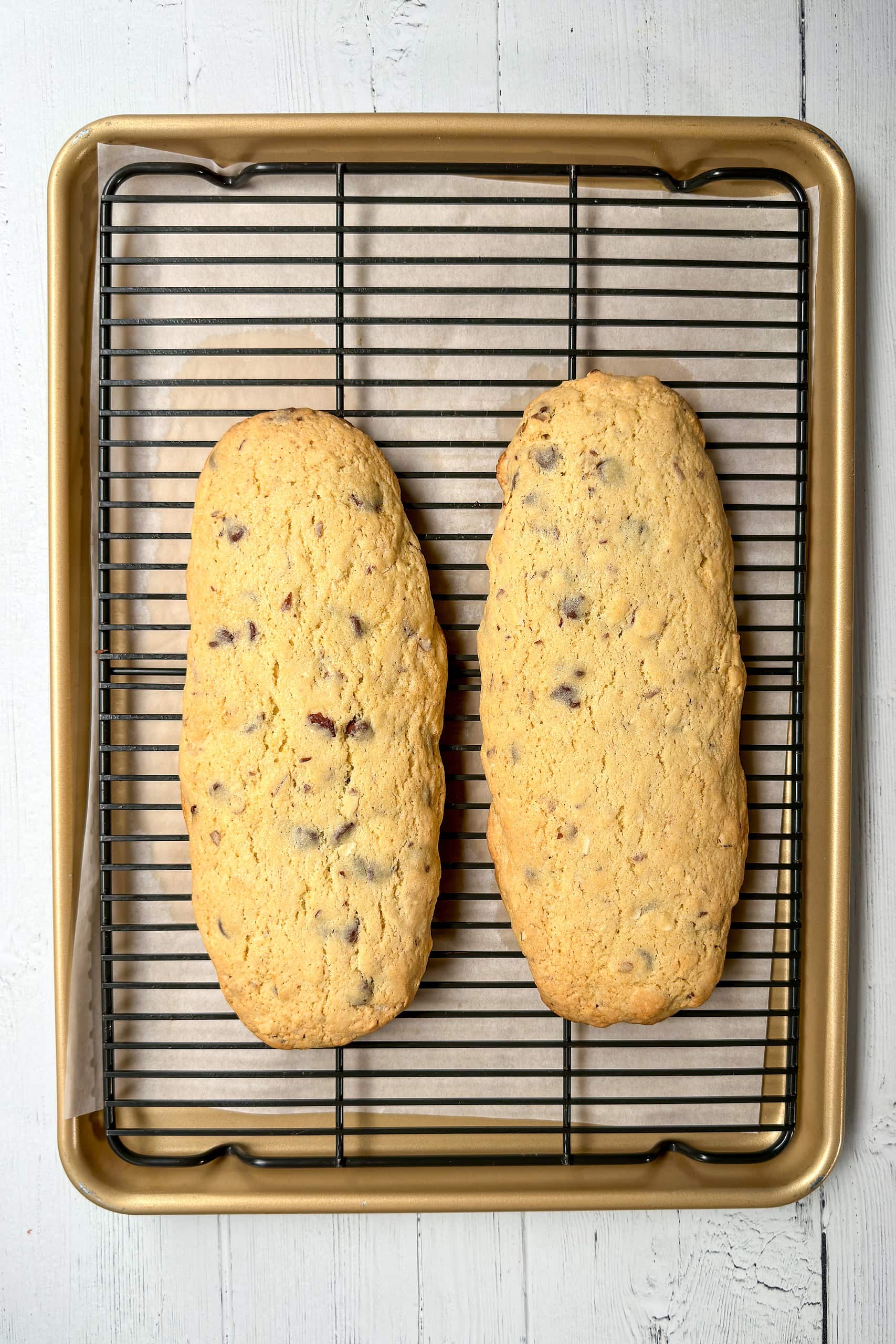 Top vertical view of baked biscotti logs cooling on a wire rack.
