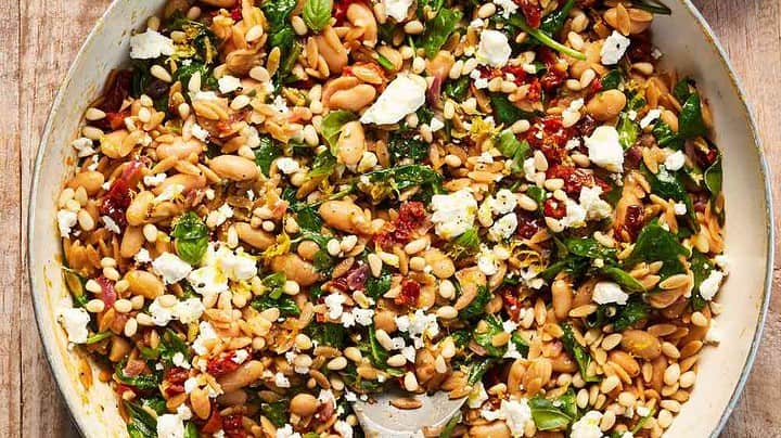 Top view of Lemon Feta Orzo Skillet in a white skillet with a blue and white kitchen linen.