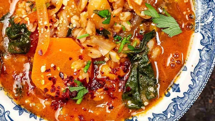 Closeup top view of farro soup with fresh chopped herbs.