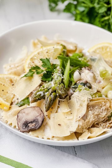 A bowl of lemon asparagus pasta with mushrooms.