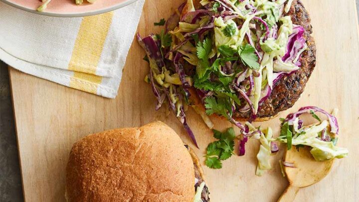 Top view of Cilantro Bean Burgers on a whole grain bun with cabbage slaw on top of patty.