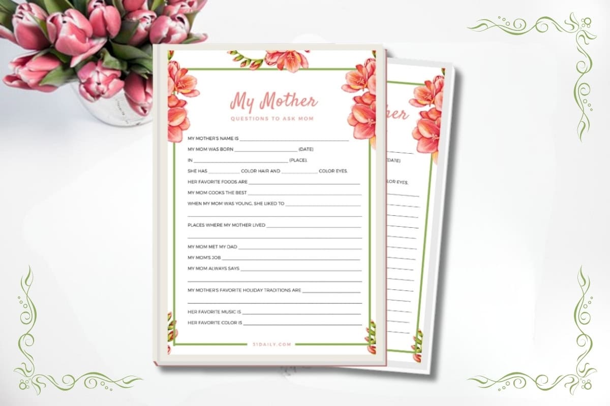 A floral-themed "Questions to Ask Mom" worksheet with fill-in-the-blank prompts, perfect for Mother's Day Questions, placed on a white surface beside a vase of pink and white tulips.