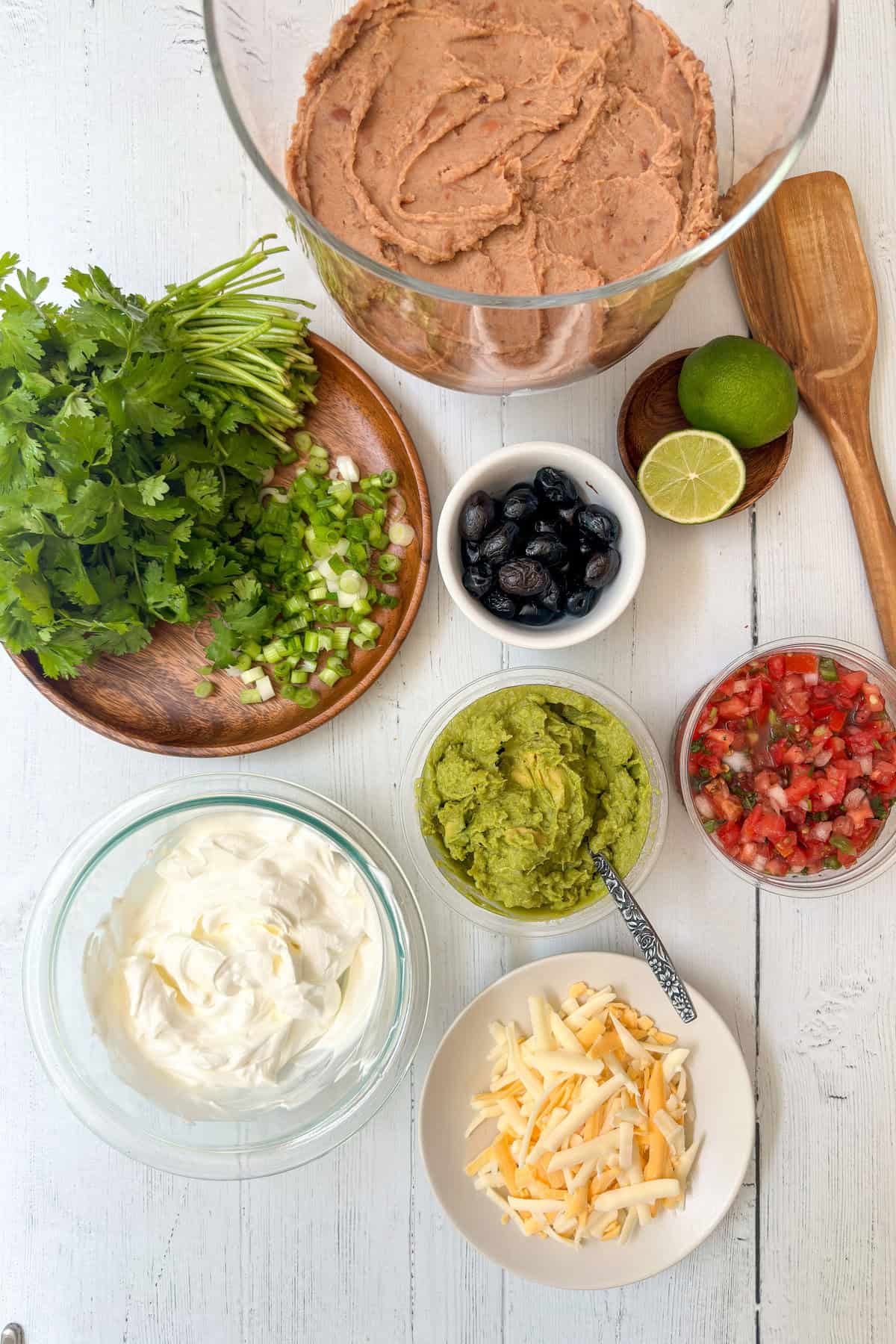 Top view of dip ingredients for the 7 layers on a white background.