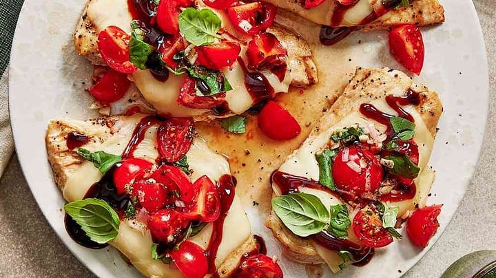 Closeup top view of chicken bruschetta with basil, mozzarella, and tomatoes.