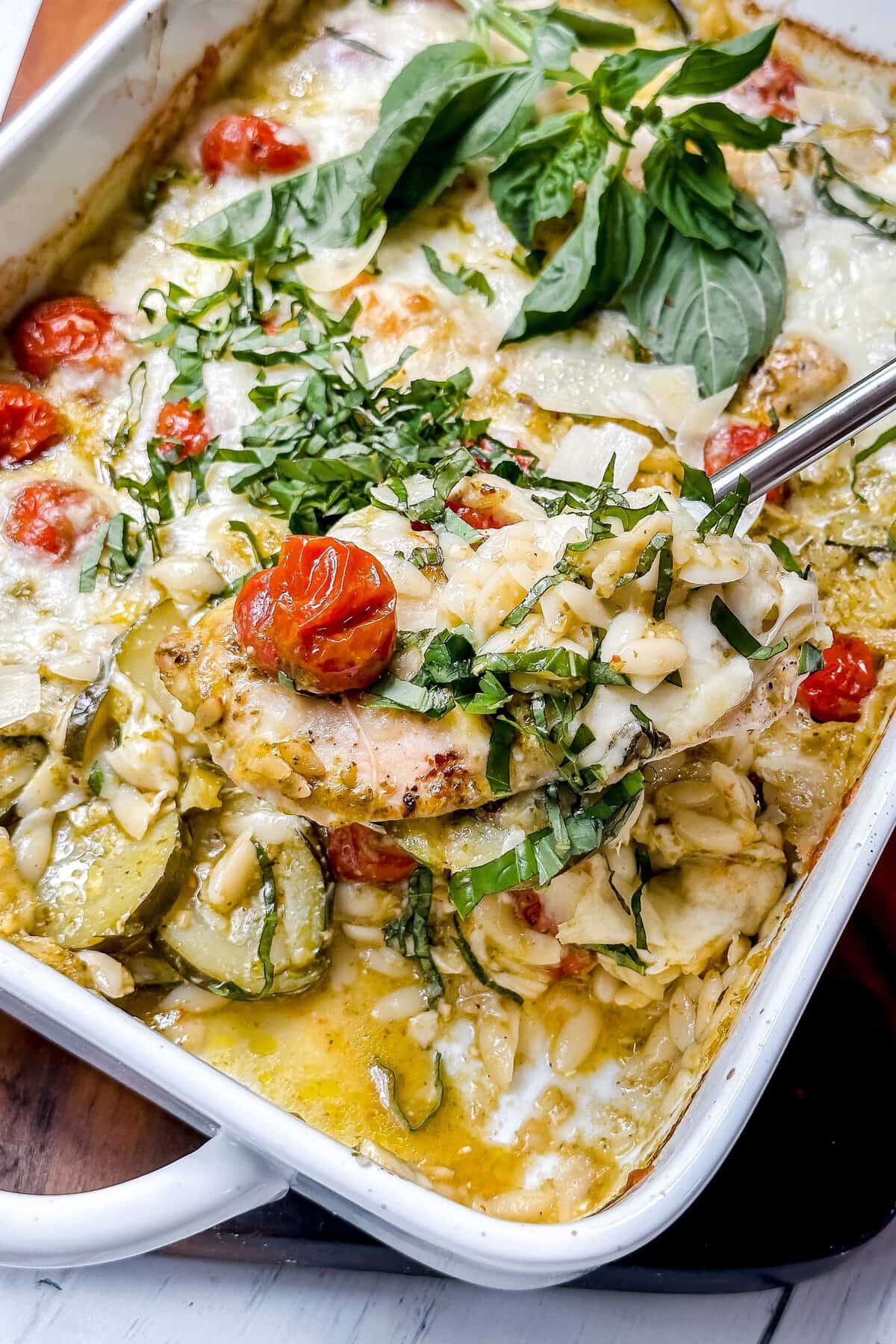 Closeup view of pesto chicken on a spoon for serving.