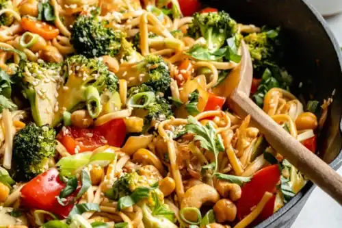 Closeup view of Vegan Stir Fry Sesame Noodles with a wooden spoon.