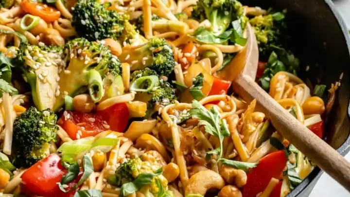 Closeup view of Vegan Stir Fry Sesame Noodles with a wooden spoon.