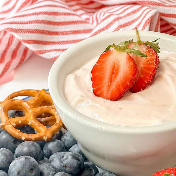 Horizontal side view of strawberry yogurt dip with sliced strawberries on top.