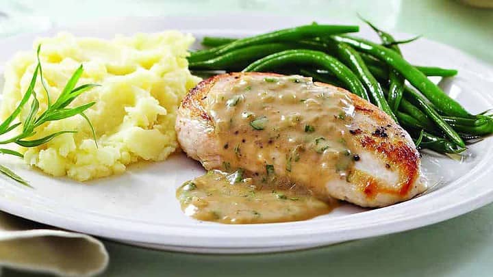 Side view of Tarragon Chicken on a white plate for Healthy French Dinners.