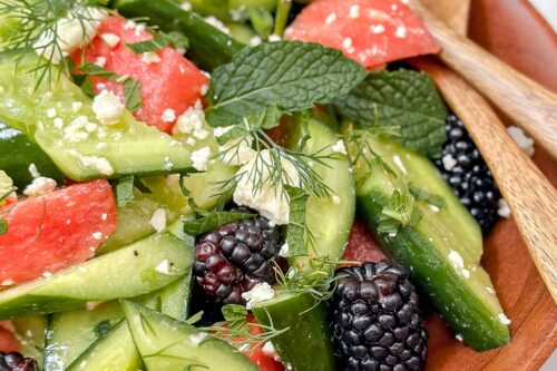 Closeup view of Smashed Cucumber Watermelon Salad in a wooden salad bowl.