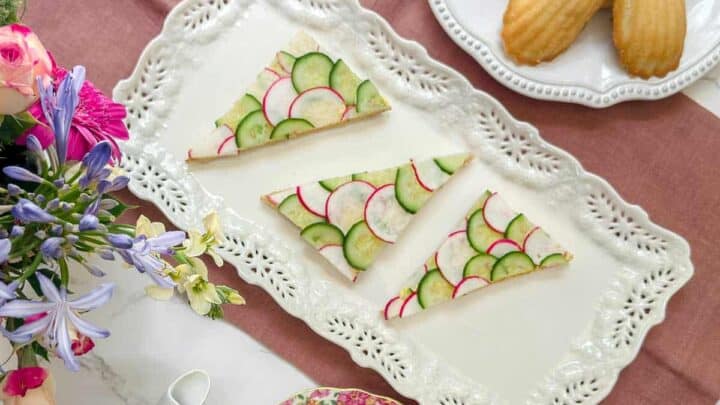 Top view of cucumber an radish tea sandwiches on a rectangular tea serving platter.