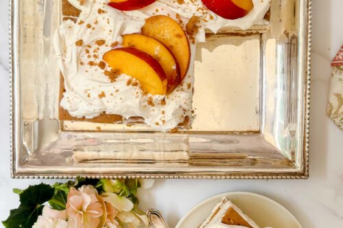 Top view of Peach Icebox Cake serving and cake on a silver platter.