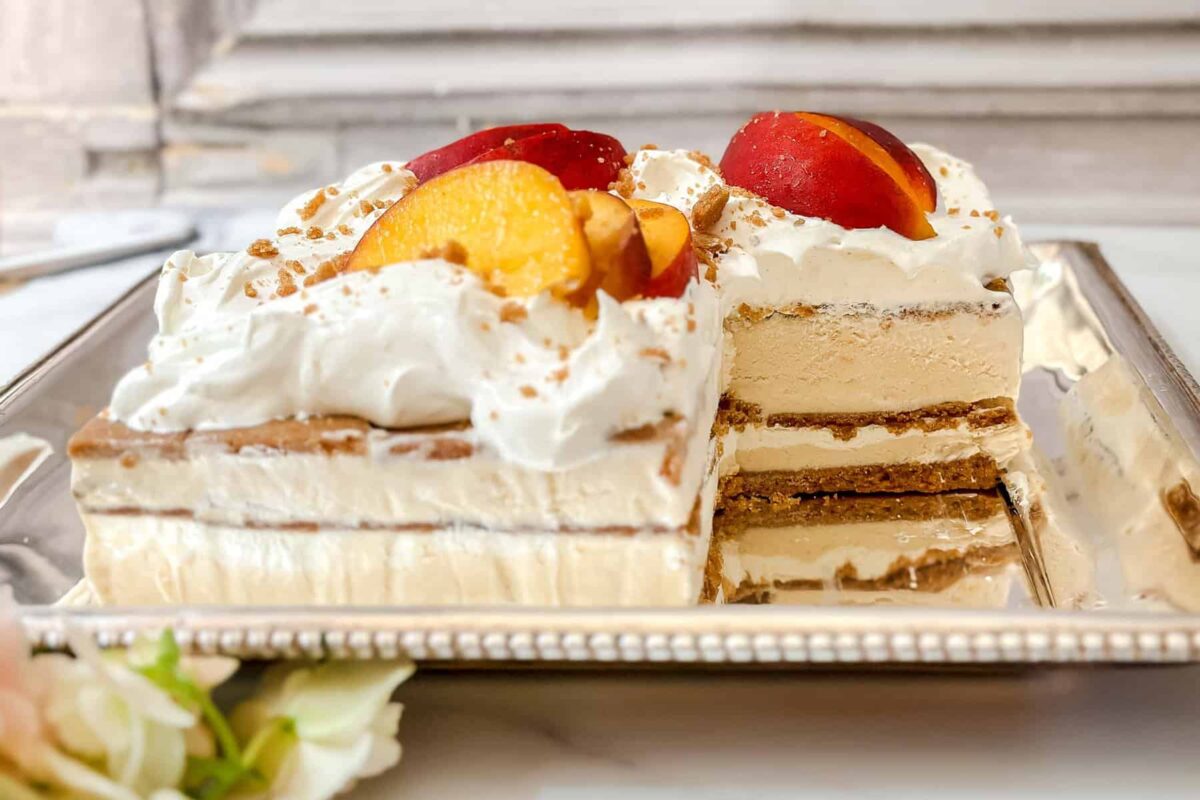 Side horizontal view of peach icebox cake with a serving missing.