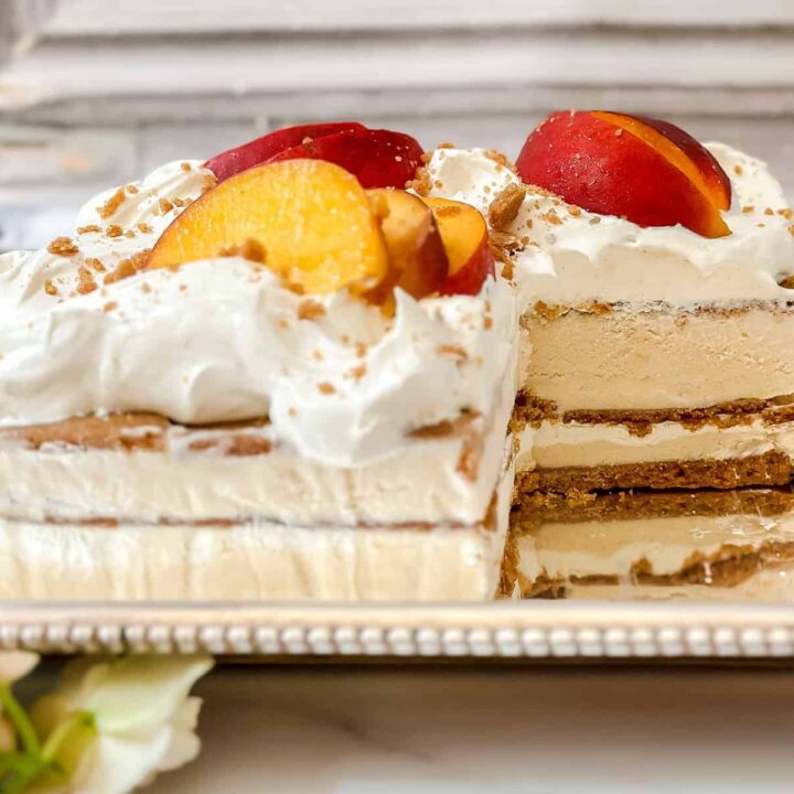Side horizontal view of peach icebox cake with a serving missing.