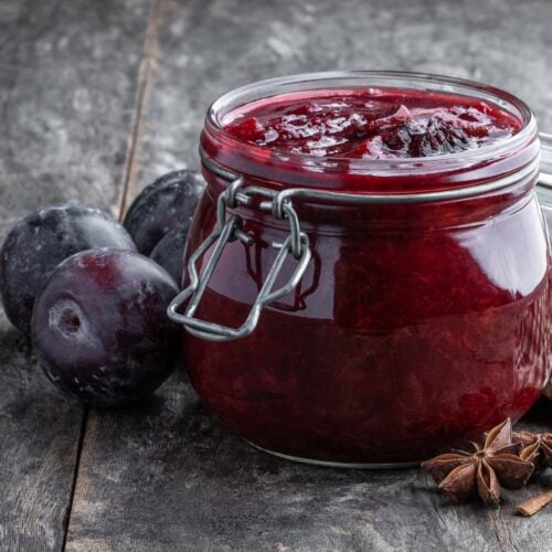 Side view of plum chutney in a glass jar.