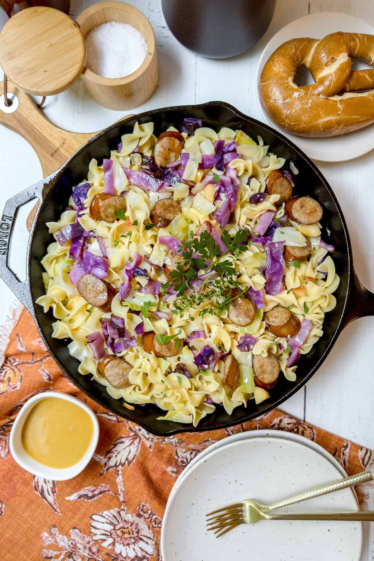 Cabbage and noodles with bratwurst in a cast iron skillet ready for serving.