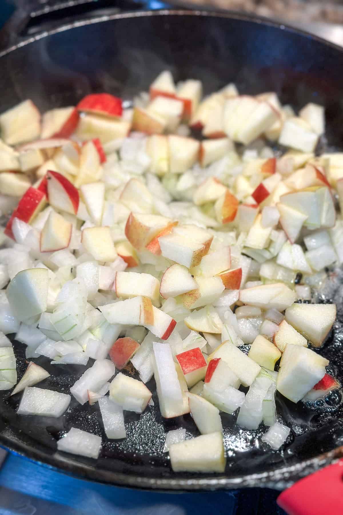 Sautéing apples and onions in a cast iron skillet.