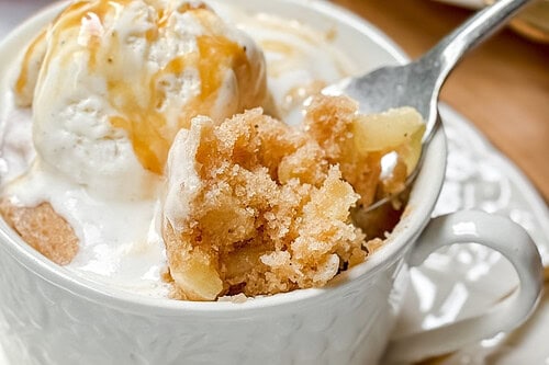 Two images feature an apple mug cake. The top image shows a mug cake topped with ice cream and caramel sauce on a white plate, while the bottom displays a partially eaten apple mug cake. Text overlay reads "3 Minute Apple Mug Cake" and "31Daily.com".
