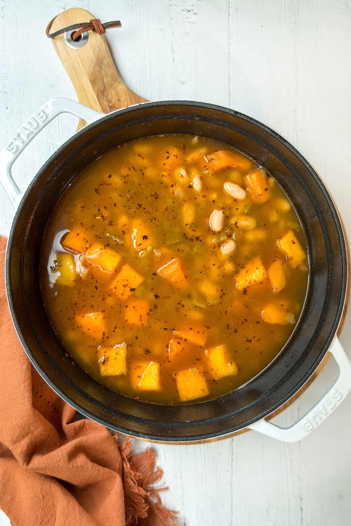 A large pot filled with chicken chili ingredients with butternut squash ready for cooking.