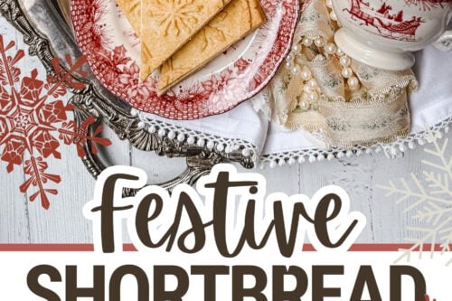 A festive setting features shortbread cookies on red and white plates, a steaming cup of tea, and decorative snowflakes. Arranged on a silver tray with pinecones and holiday trimmings, this cozy winter scene invites warmth. The text reads "Festive Shortbread Cookies.