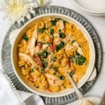 Top view of Marry Me Chicken Soup in a handled serving bowl with parmesan cheese on the side.