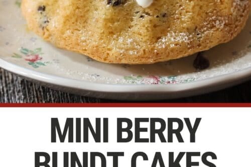 A mini bundt cake topped with strawberries, mint leaves, and a drizzle of white icing sits on a floral plate. The cake is dusted with powdered sugar. Text below reads, "MINI BERRY BUNDT CAKES.
