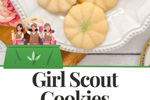 A plate of six flower-shaped Girl Scout Cookies with green sugar centers sits on a white dish. Text below reads “Girl Scout Cookies 1922 Original Recipe” with an illustration of three girls in uniforms.