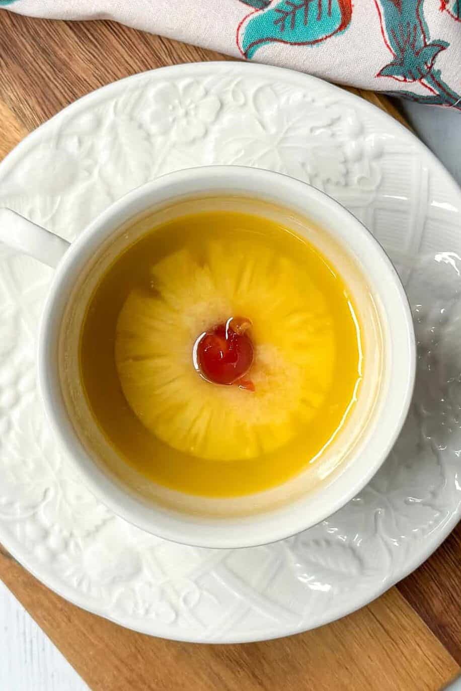 A cup of tea with a pineapple on top.