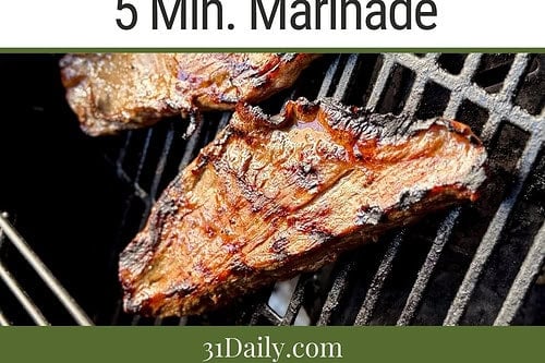 A bowl of sliced Lemon Ginger Teriyaki steak served over rice with herbs and green onions, next to a plate of grilled steak pieces and small bowls of sauces and corn—a delicious 30 Minute Recipe for Steak and Rice lovers.