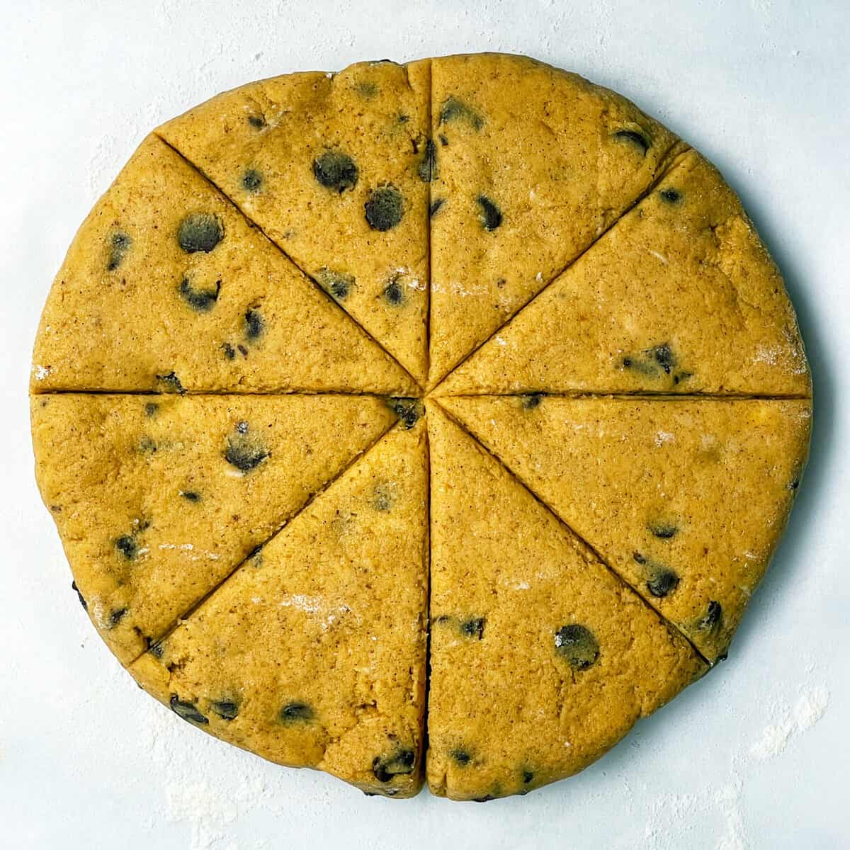 Scone dough shaped into a disk and cut into 8 wedges.