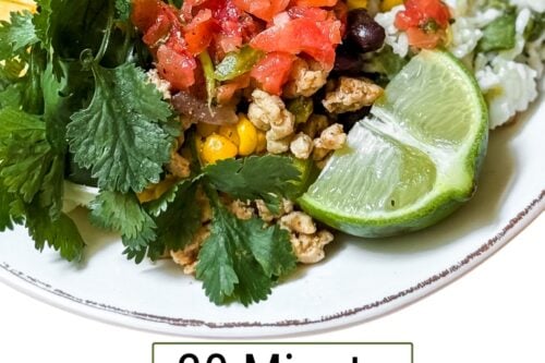 A taco bowl with ground meat, black beans, corn, rice, diced tomatoes, cilantro, lime, and a cooked egg. Text reads: "Easy Chicken Taco Bowls in 30 Minutes—One Skillet Meals from 31Daily.