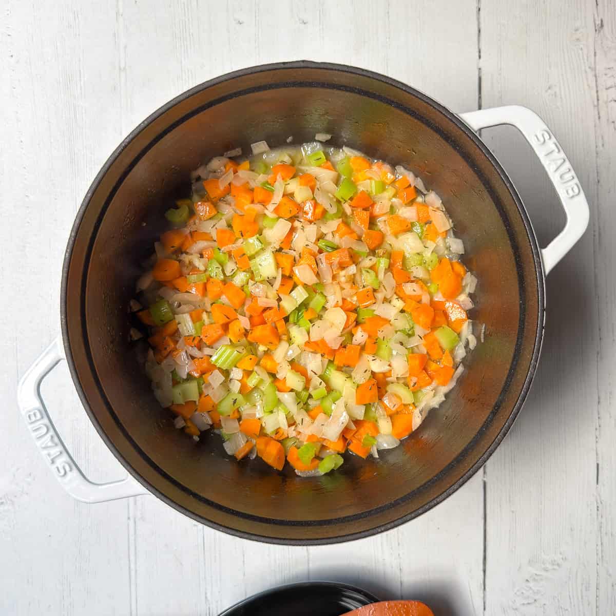 Vegetables sautéing in a large pot for soup.
