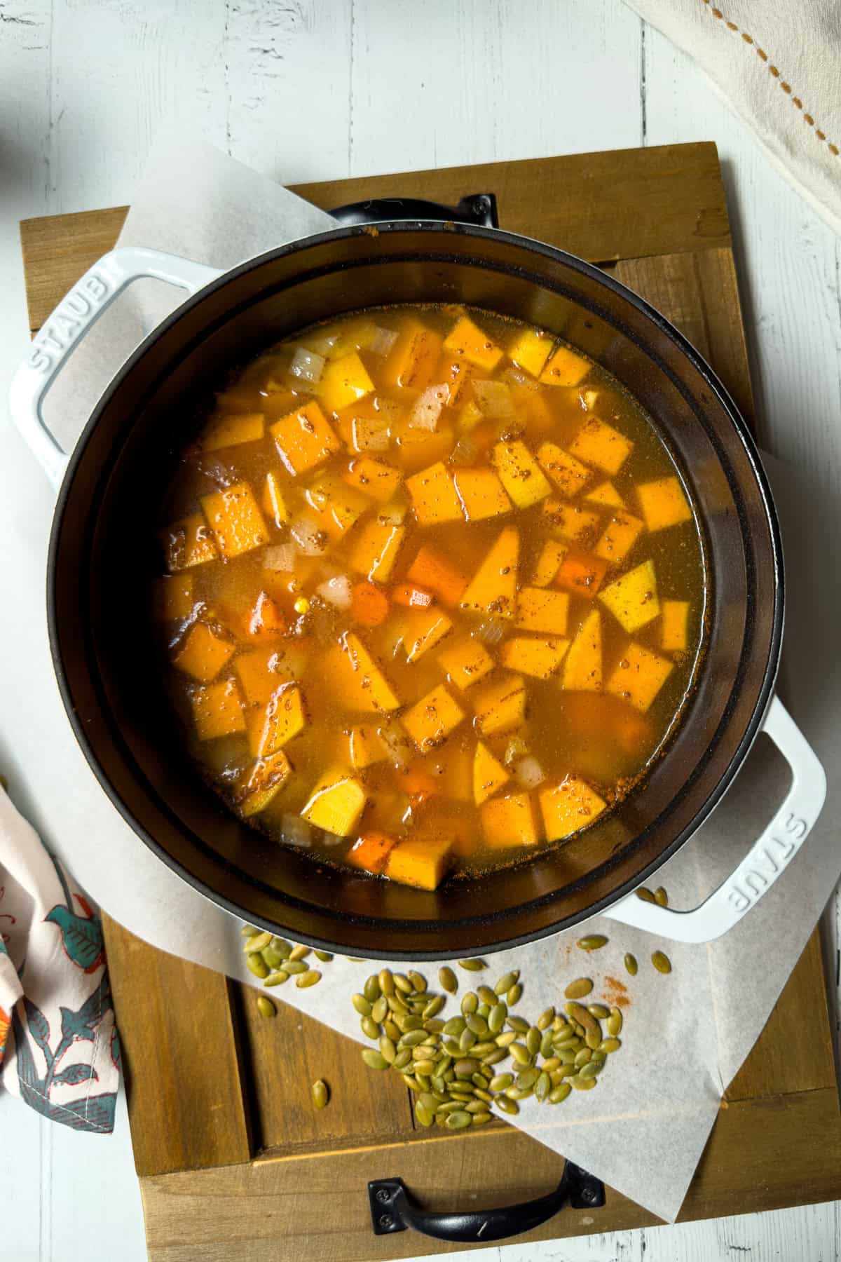Butternut squash and carrots simmering in broth and apple cider.