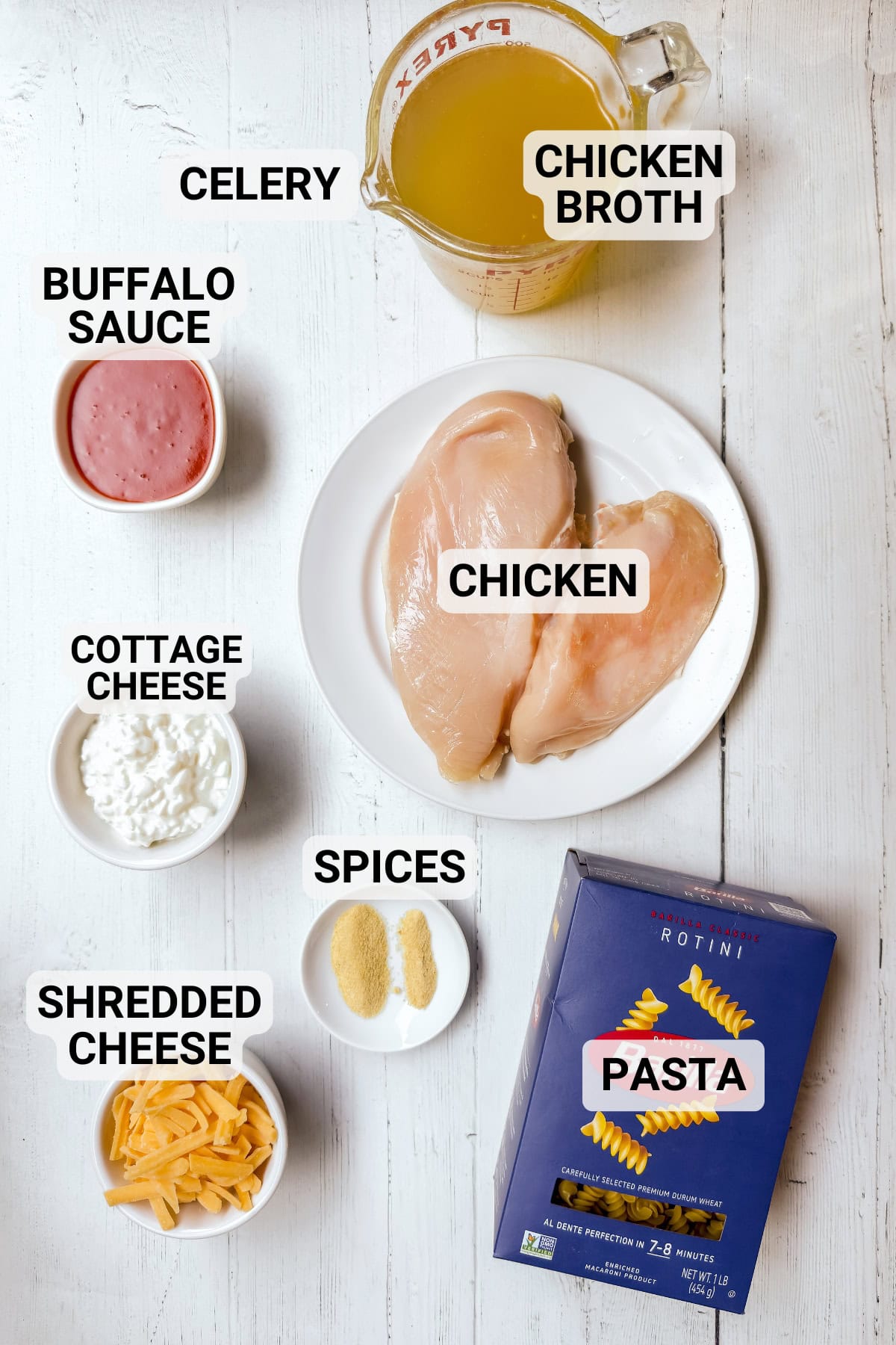 Ingredients for Crockpot Buffalo Chicken Mac and Cheese including chicken breasts, pasta, Buffalo sauce, cottage cheese, and shredded cheddar.