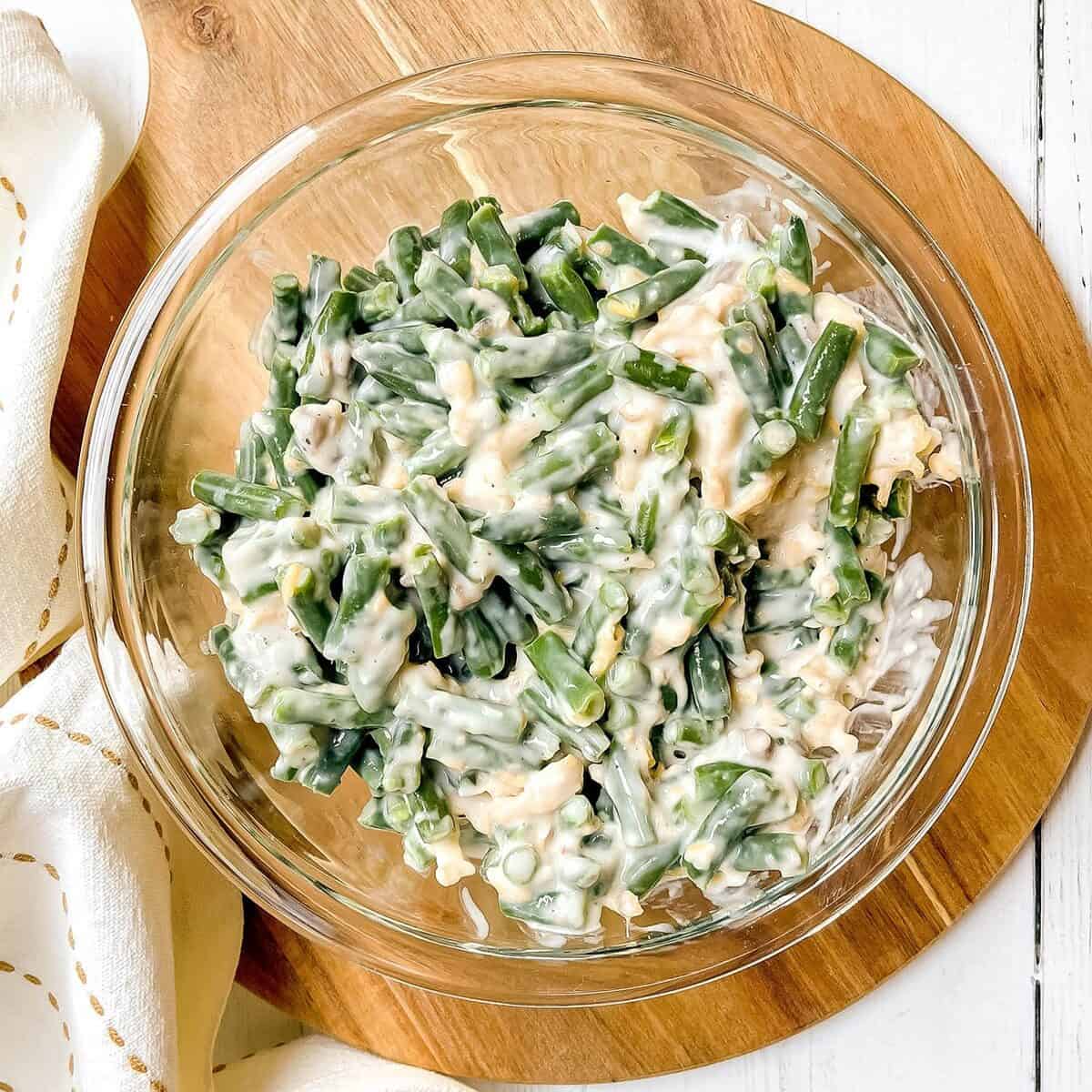 Green bean casserole filling in a glass bowl ready for a baking dish.