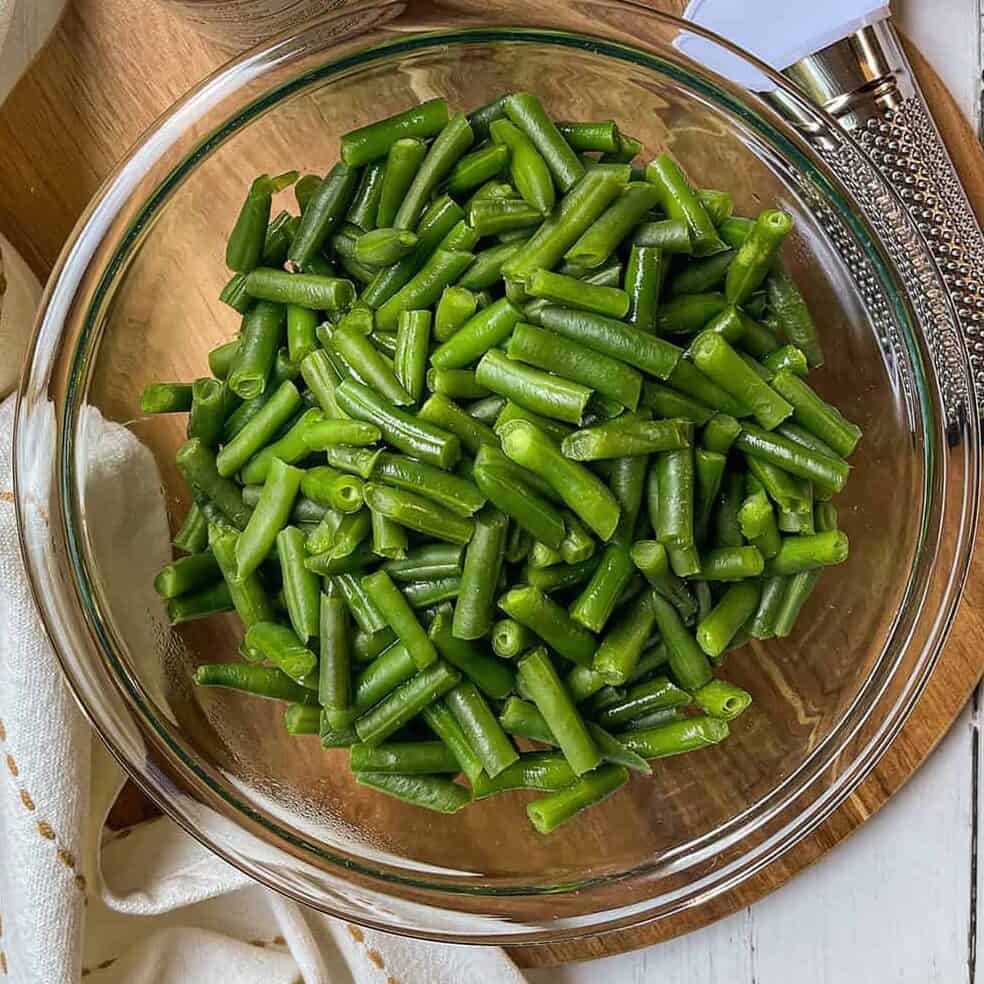 Fresh green beans ready for pre-cooking in a glass bowl.