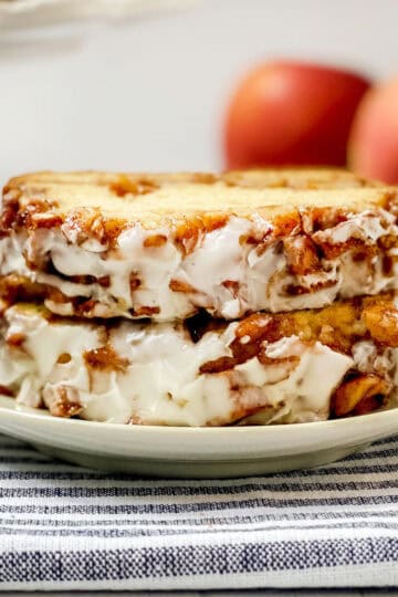 Two slices of apple fritter bread with a streusel apple topping and icing sitting on a plate ready for serving.