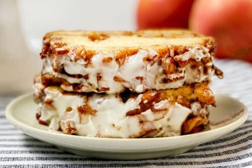 Two slices of apple fritter bread with a streusel apple topping and icing sitting on a plate ready for serving.
