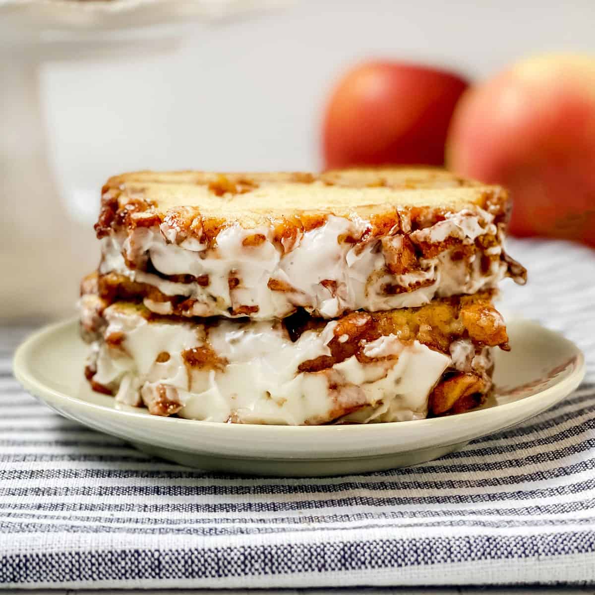 Two slices of apple fritter bread with a streusel apple topping and icing sitting on a plate ready for serving.