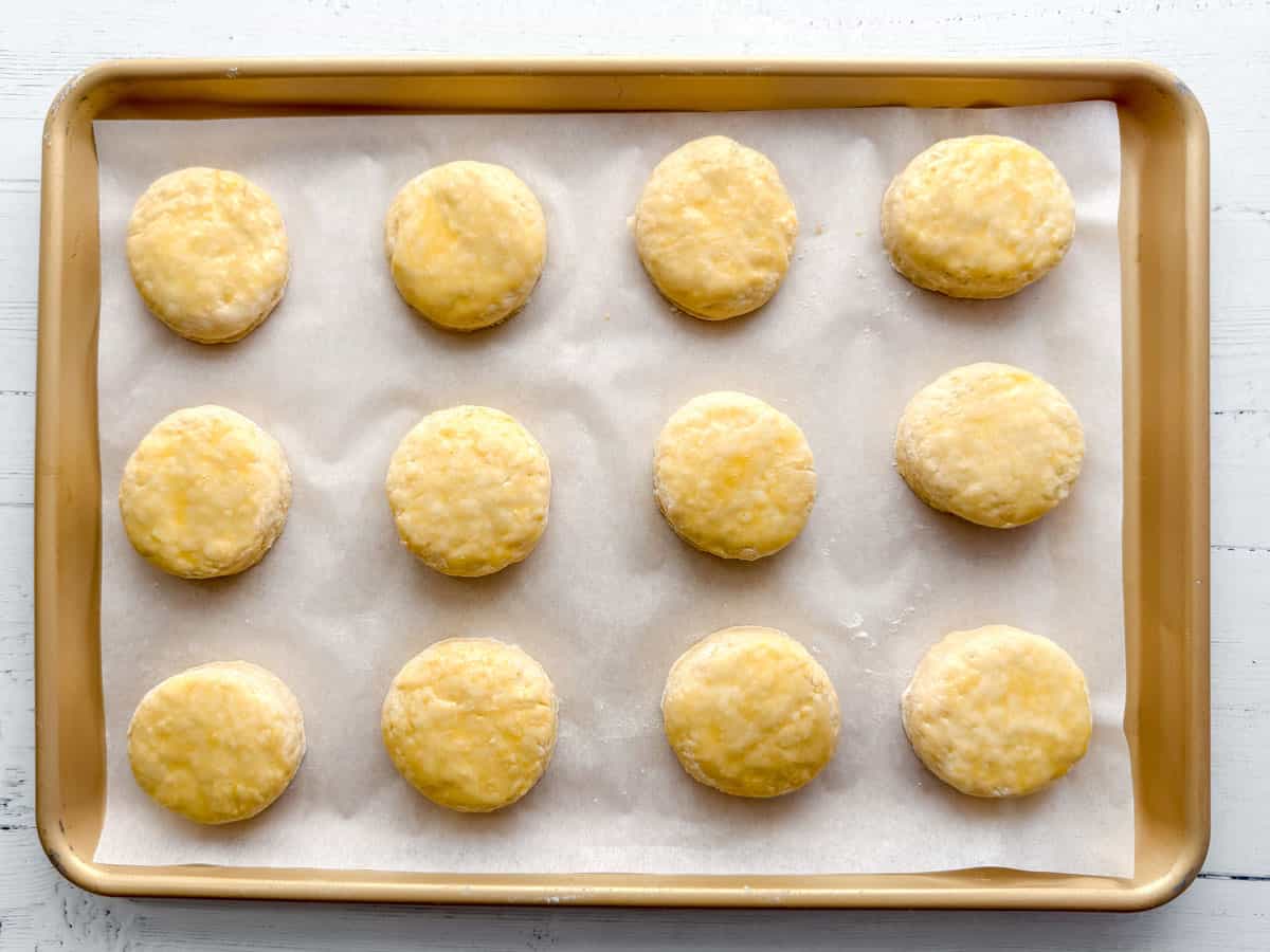 Unbaked scones brushed with egg wash on baking tray.