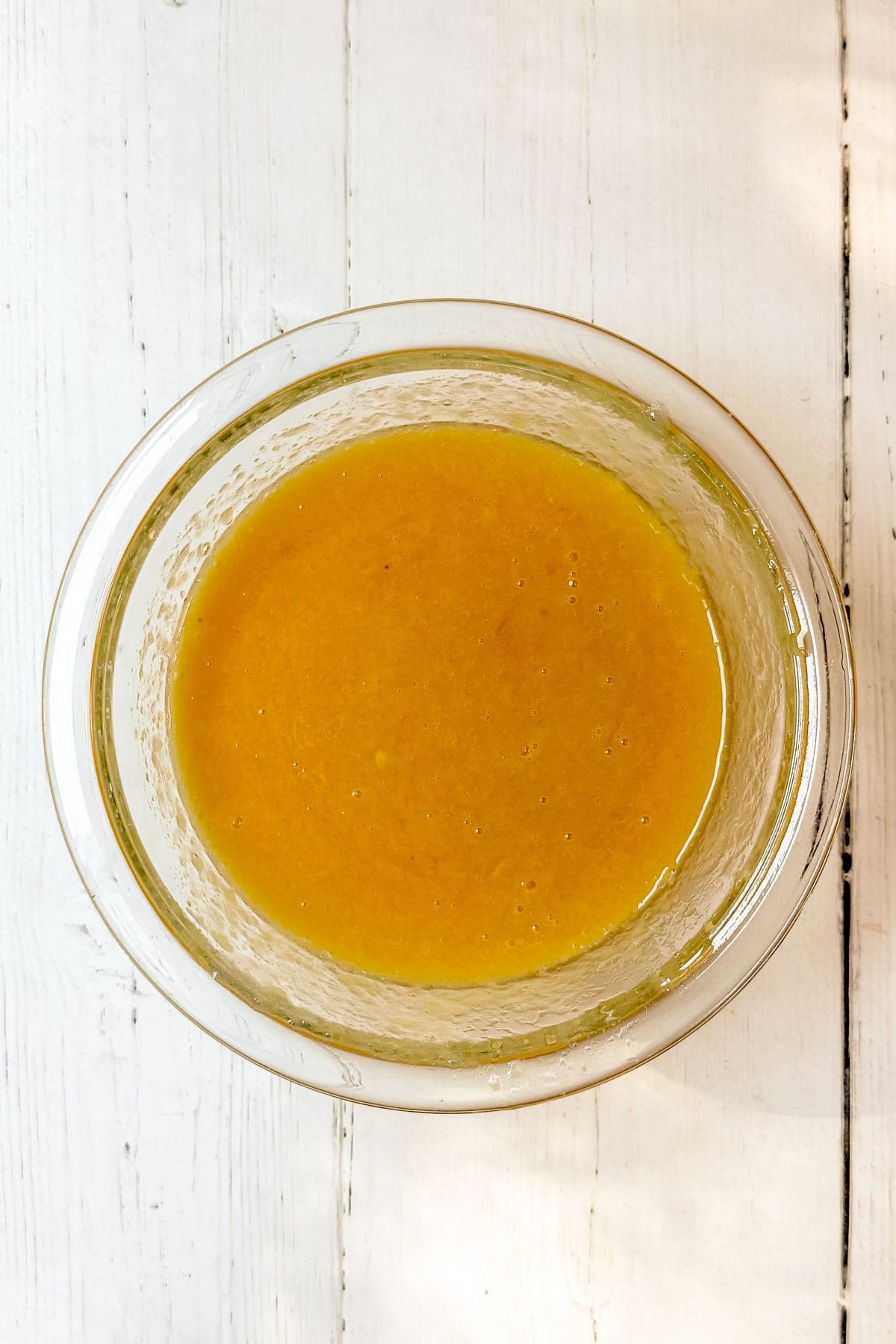 Bowl of wet ingredients whisked until smooth for apple muffin batter.