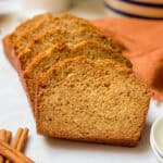 Closeup view of sliced banana bread on a white marble cutting board.